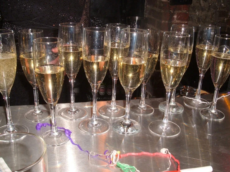 champagne glasses lined up on a table in the dark