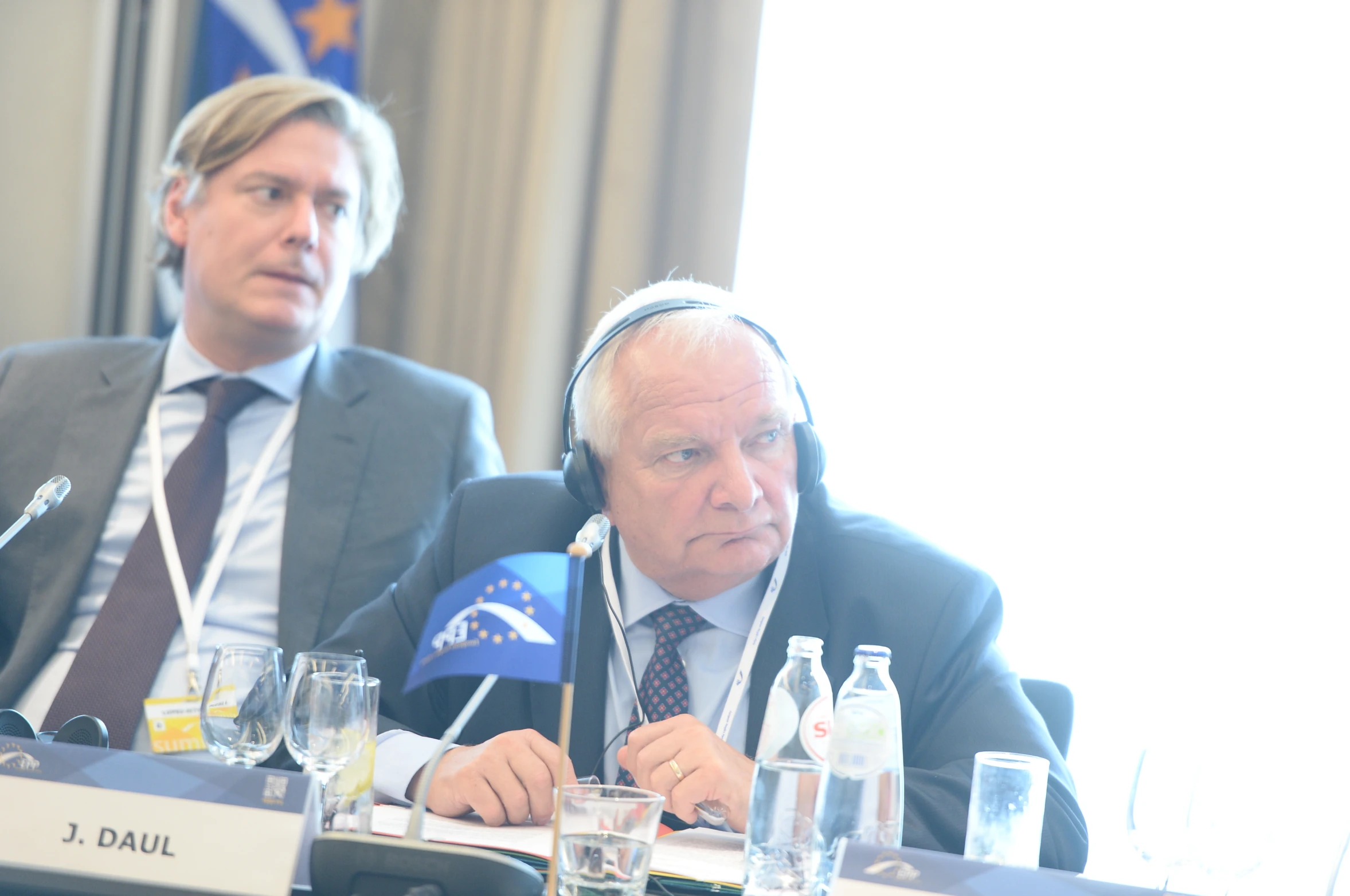 two men in suits sitting at a table