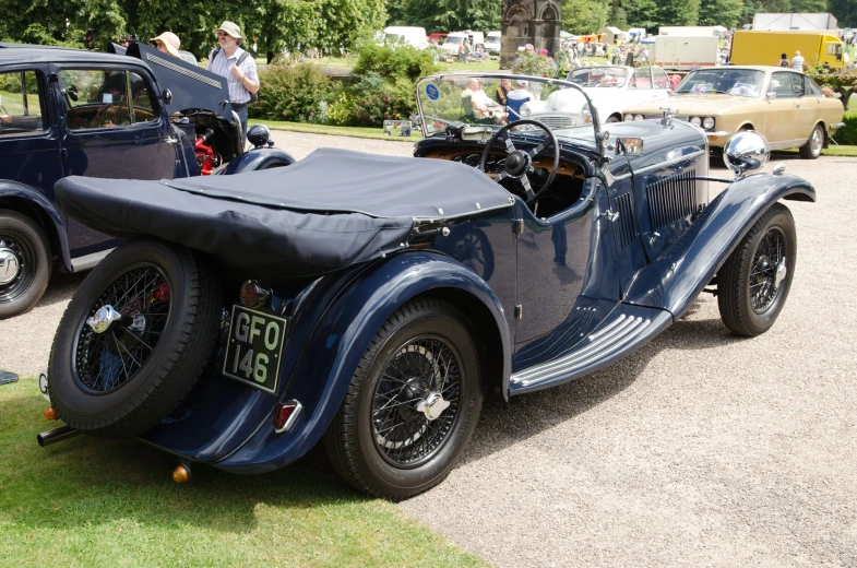 an old vintage car with a black cloth top and seat cover