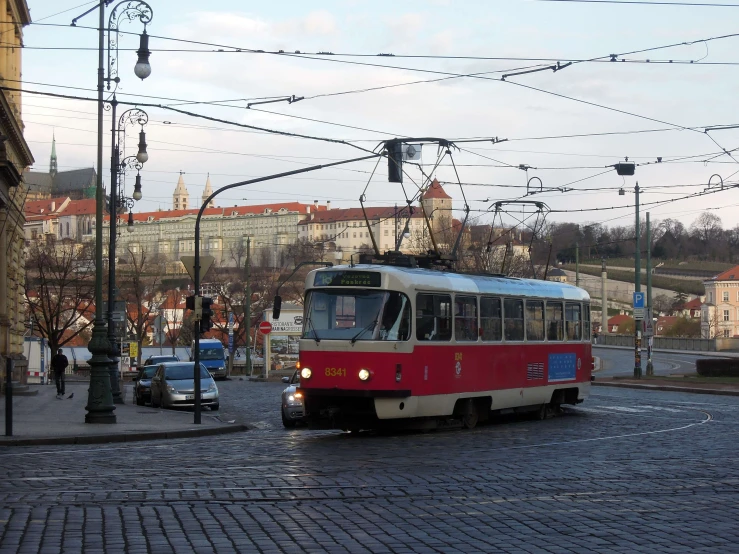 a red and white trolly on a street in the city