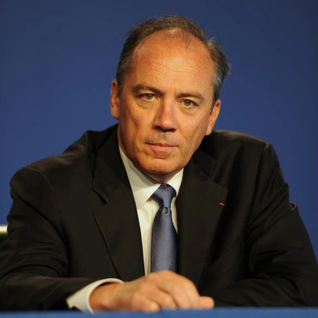 a man is posing for a po in his suit and tie