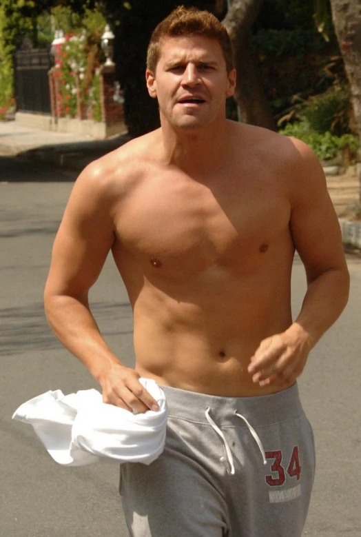 a shirtless man is walking in the street