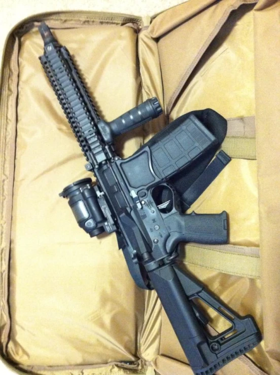 an ar - 15 rifle is displayed with the strap closed and another gun lying in a packed bag