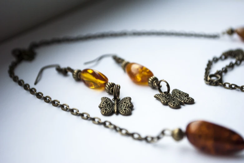 this necklace is adorned with two erfly shaped glass beads and hangs on a chain