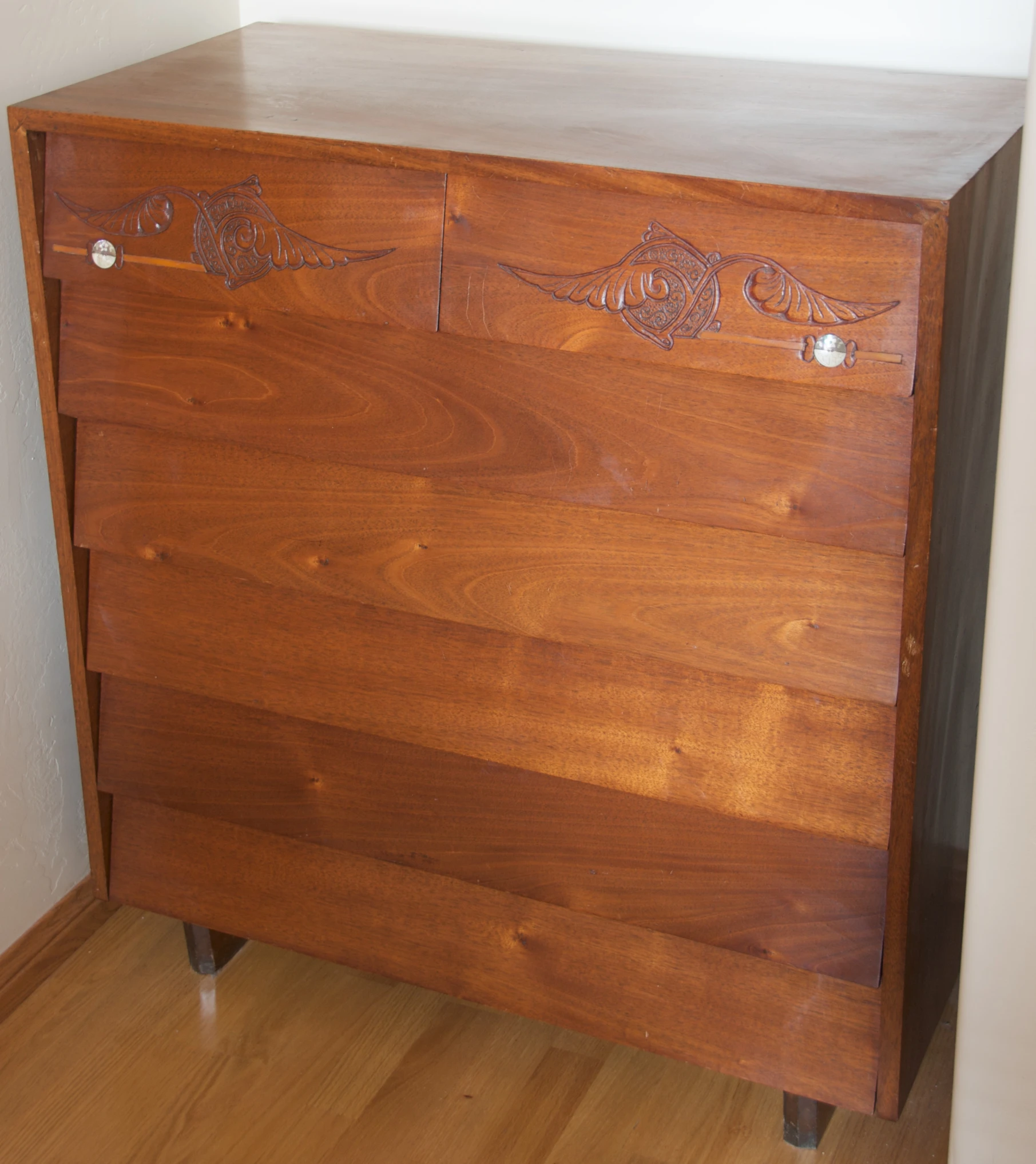 a chest with some carvings in it is sitting on a wooden floor