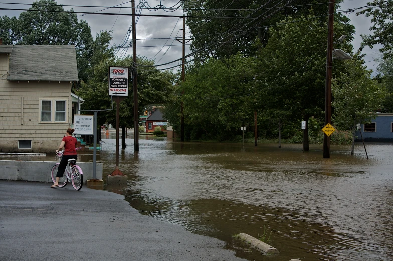 a man riding a bicycle through a flooded street