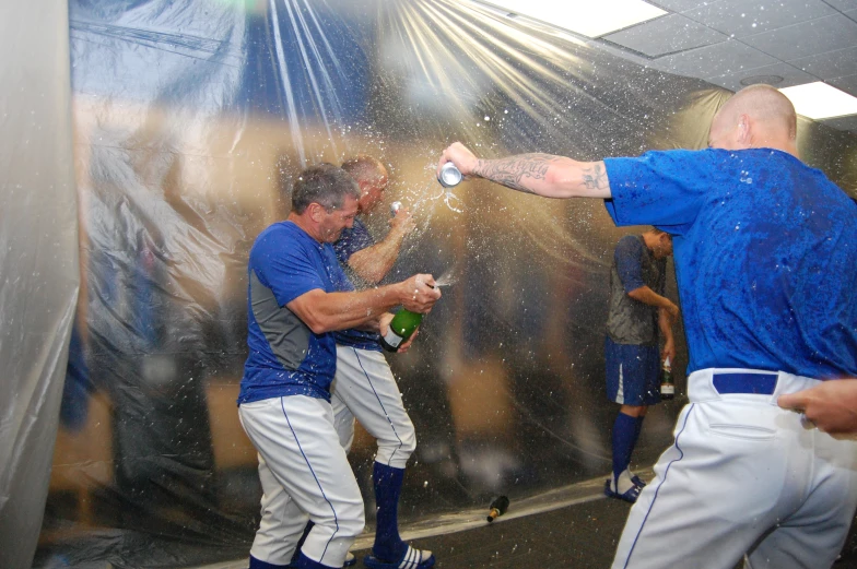 baseball players spray champagne at each other