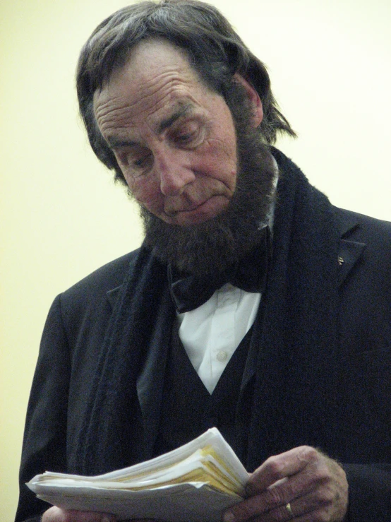 a man dressed in a suit reading soing