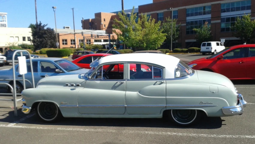 an old fashioned car in the parking lot