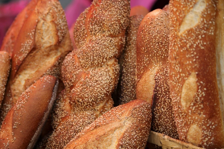 a basket filled with lots of sesame seed rolls