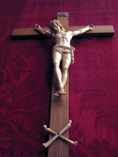 a cross with a statue of jesus sitting on top of it