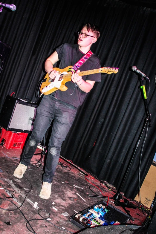 a man standing on a stage while holding a guitar