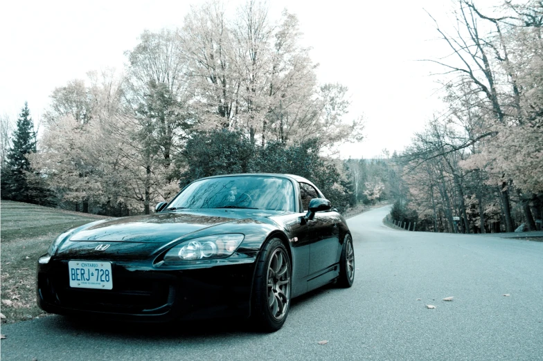 a black sports car is driving down the road