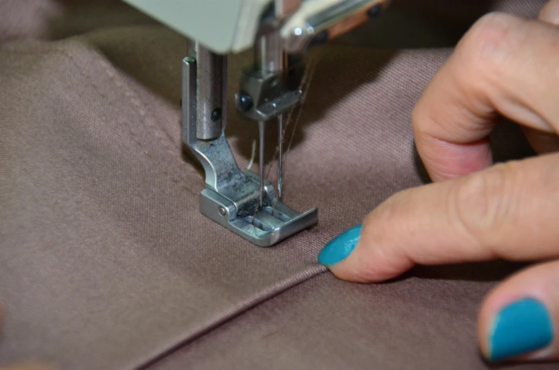 a woman's hand operating a sewing machine