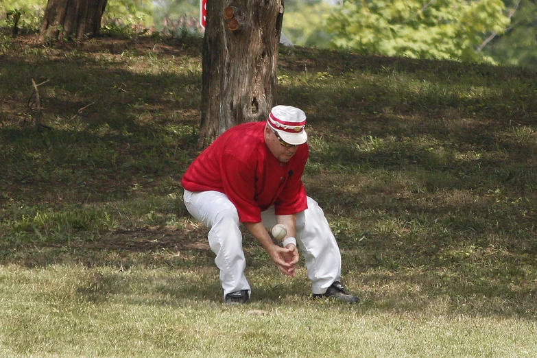 an older person holding a baseball in their left hand