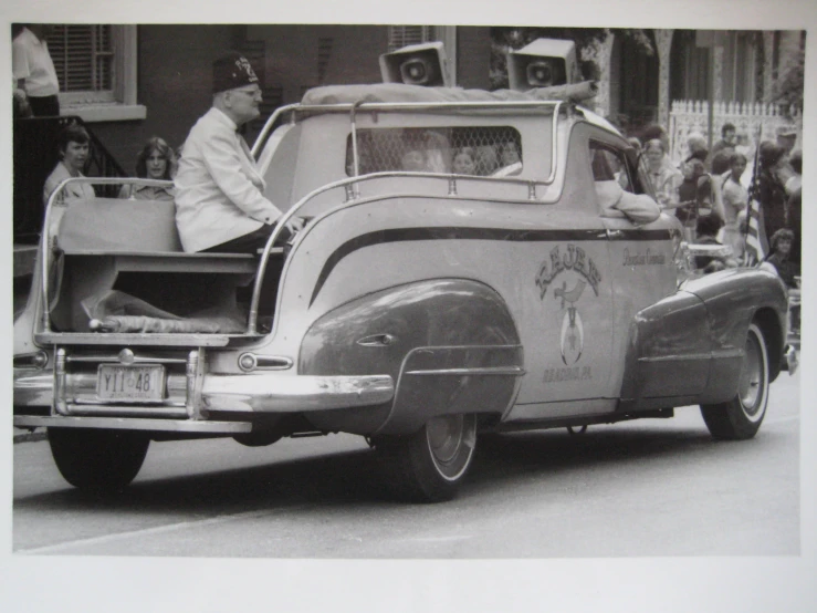 a classic pograph of an old car with a back seat open