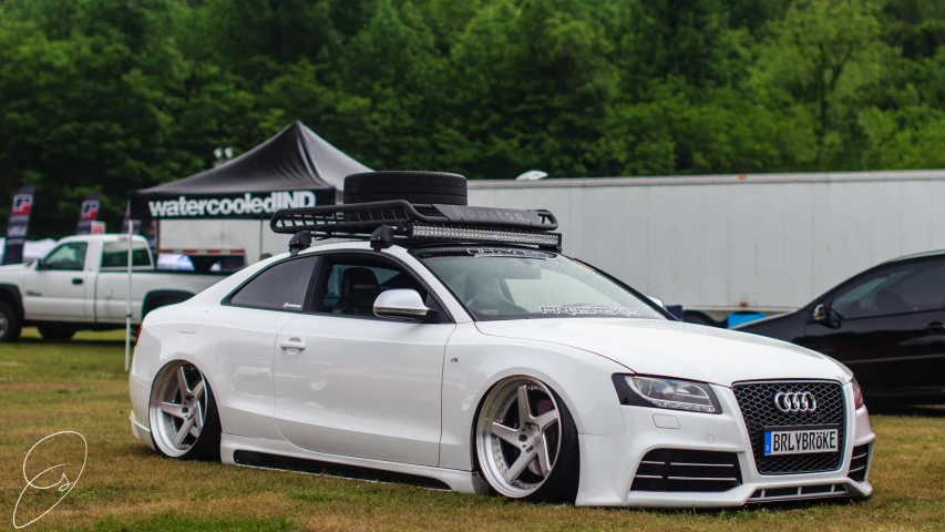 an automobile with skis on top parked in the grass