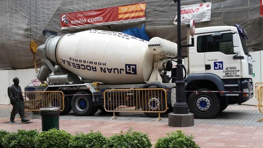 a man is standing next to a cement truck