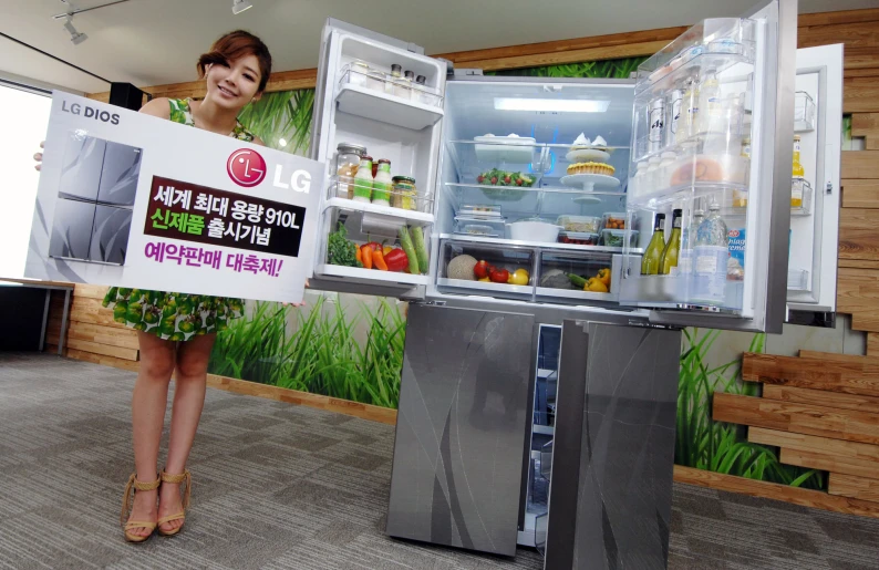 a woman holding a sign in front of a refrigerator