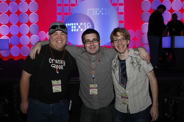 three men pose for a picture while holding each other