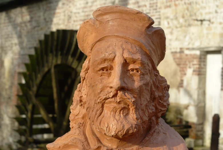 a sand sculpture of a bearded man with a cap on