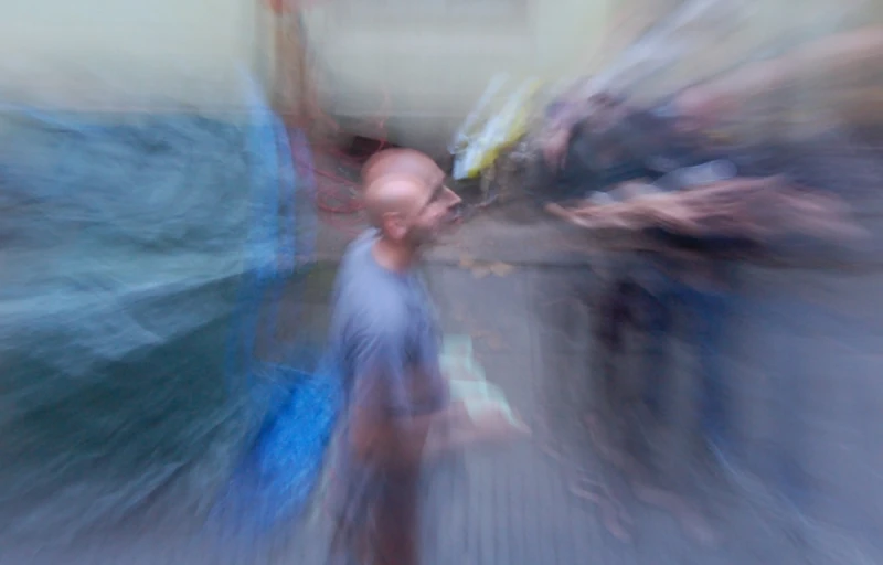 blurry pograph of man holding bags looking up