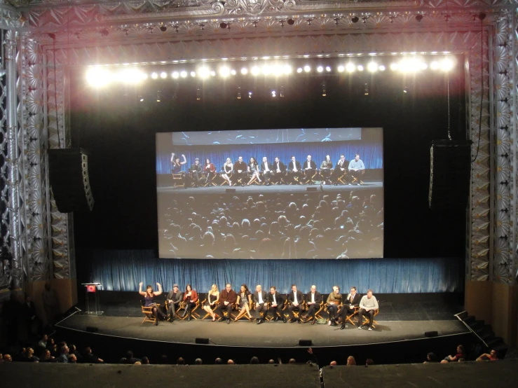 a concert scene with people and a large screen