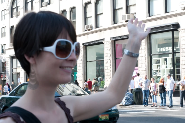 a woman waving on the street in front of a building