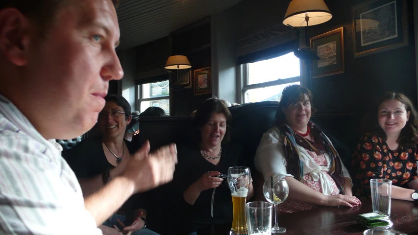 a group of women and men are having drinks in a restaurant