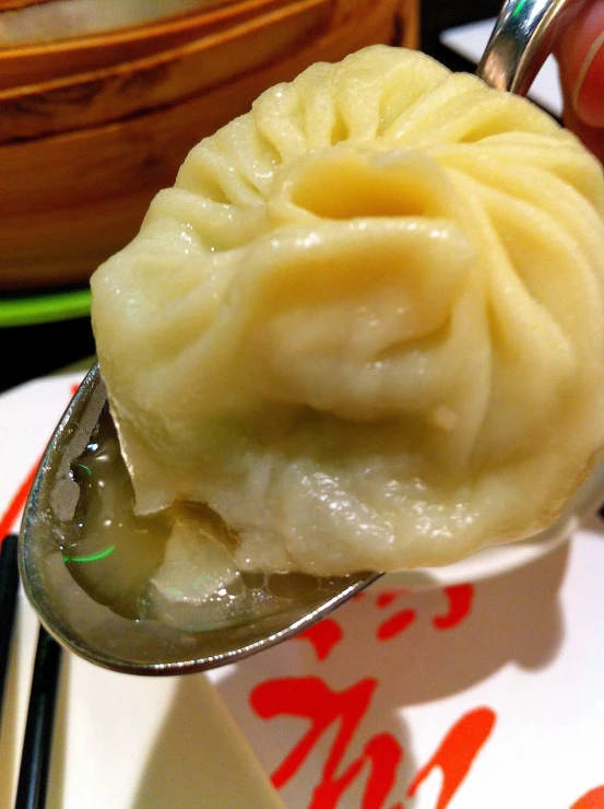 closeup of fork with asian dessert on dish and chopsticks