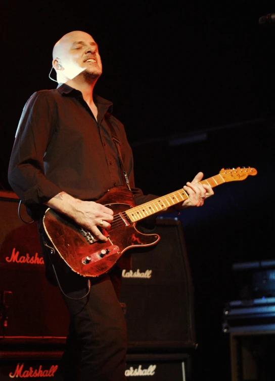 a man standing up with a red guitar