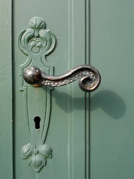 a door handle and the handle is on a green door