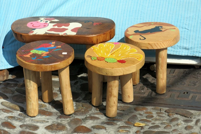 three childrens stools are sitting on a stone patio