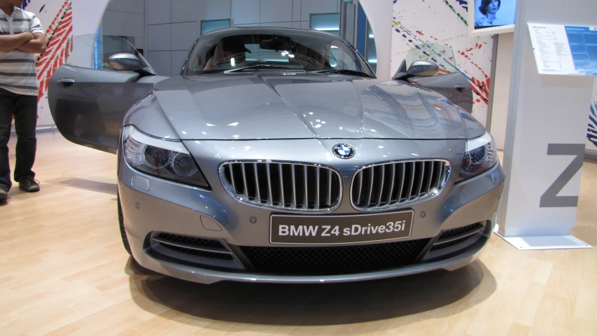 a bmw vehicle parked in a showroom, with a person talking