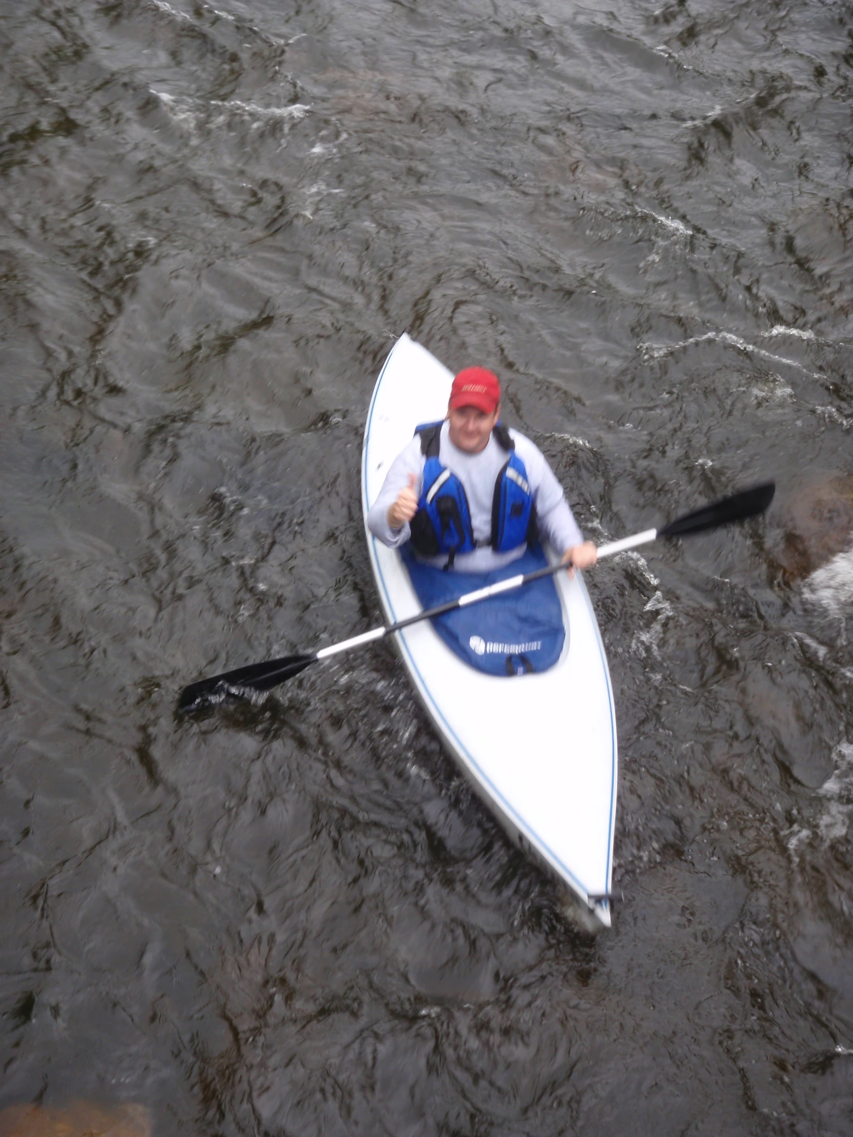 a man is riding in his boat and wearing a red bandana