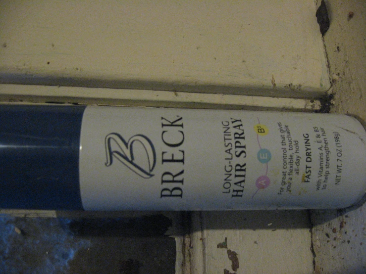 a bottle of brock long letting hair spray sitting on the side of a door