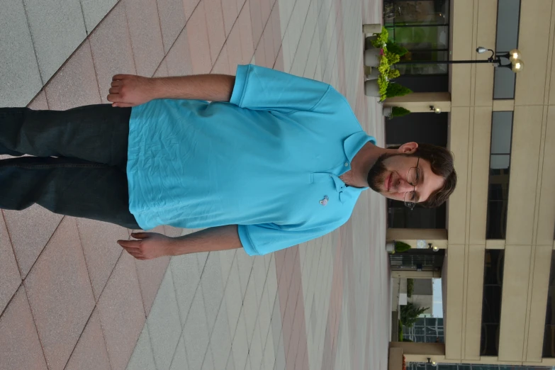 a man wearing a blue shirt posing for the camera