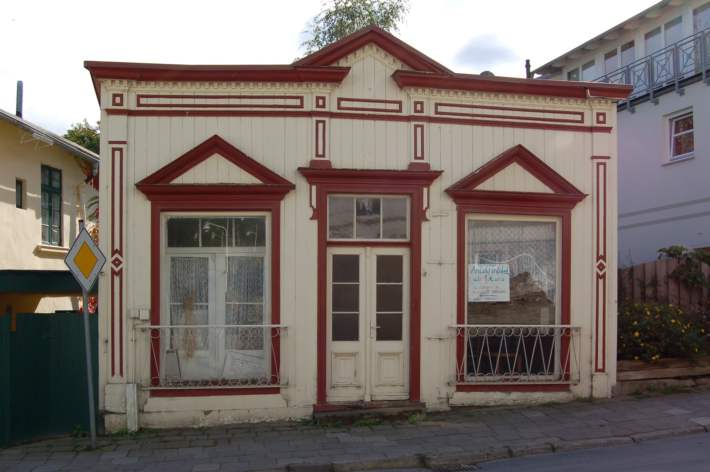 an old building with a white and red trim and shutters