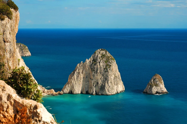 several white rocks are in the blue water