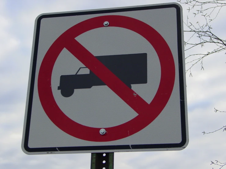 a no truck sign in front of a blue sky