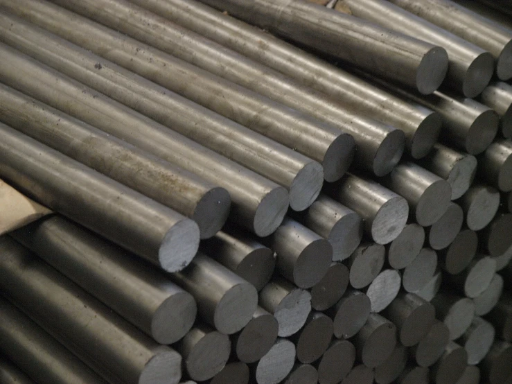 several stacks of steel bars on a rack in a warehouse