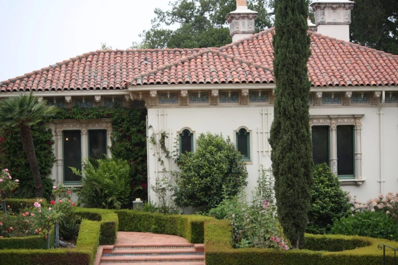 a house with hedges and trees all around it