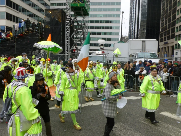 several people walking in a parade in neon yellow outfits