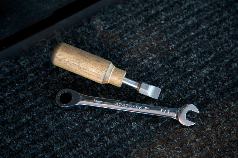 a wrench and small plastic cap are laying on a surface