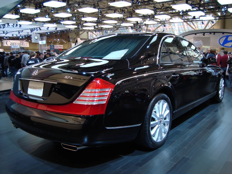 the black and red car is parked in a show room