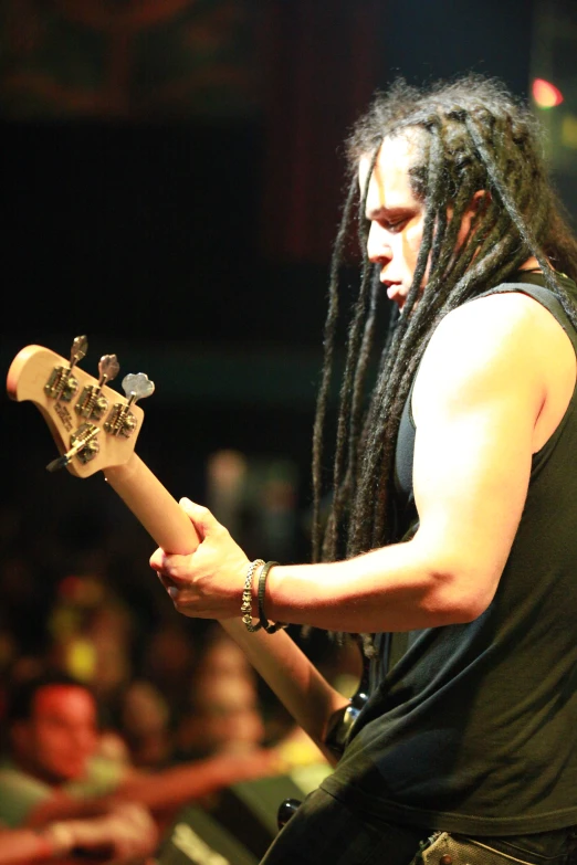 a man with dreadlocks plays a guitar