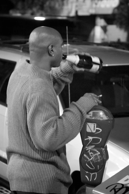 man with binoculars on his ear using parking meter