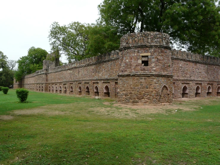 a brick building sits in the middle of the grass