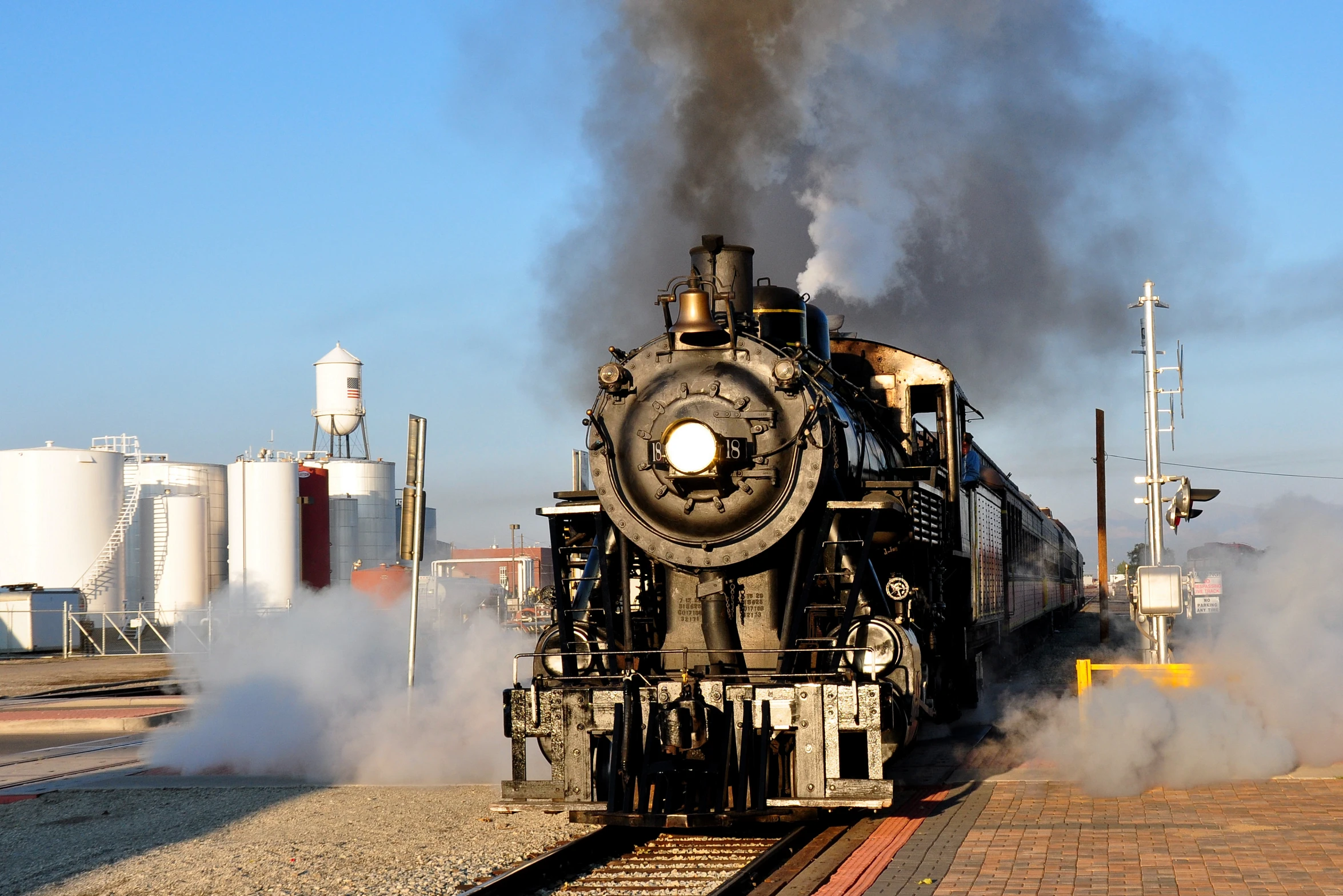 a steam engine train is going down the tracks