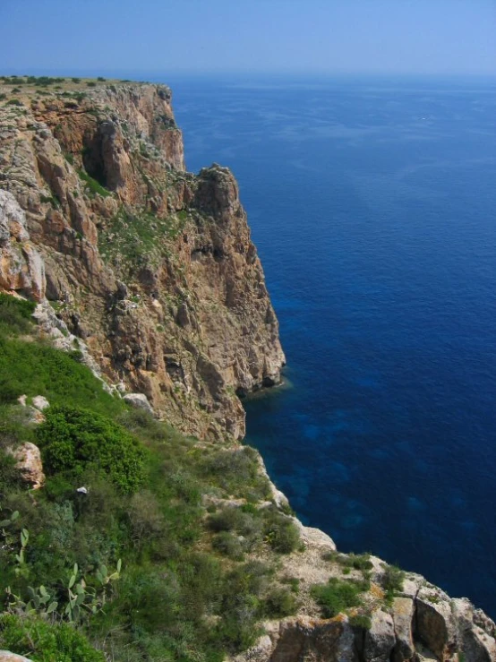 there is a rocky cliff in the blue water